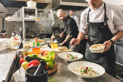 Professional chef cooking in the kitchen restaurant at the hotel, preparing dinner.