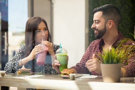 Smiling young couple drinking smoothies